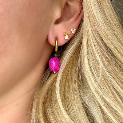 pendientes aro con piedra natural fucsia y baño de oro puestos en oreja