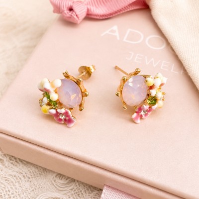 Pendientes de flores esmaltadas con piedra rosa y baño de oro sobre caja regalo