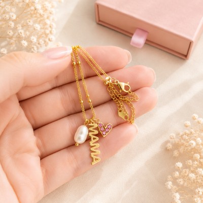 Collar para mamá dorado con perla natural y corazón rosa sujetado en mano femenina