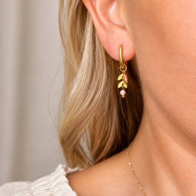 Pendientes de aro dorados con cuarzo rosa y hojas lucidos por una modelo