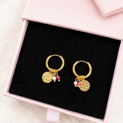 Pendientes pequeños de aro con jade rojo y perla natural puestos en modelo