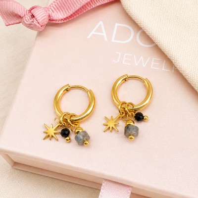 Pendientes de aro dorados con estrella, labradorita y cristal negro sobre caja regalo AdoraVi