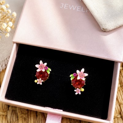 Pendientes de flores rosas con piedra roja sobre caja regalo AdoraVi