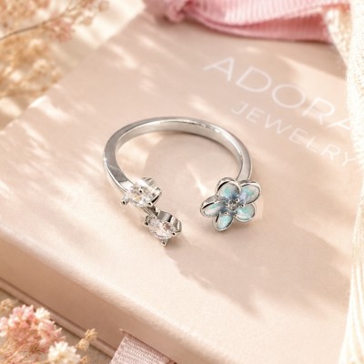 Anillo floral plateado con cristales sobre caja de joyería ADORAVI
