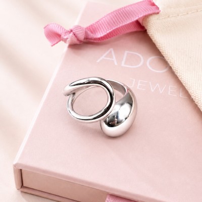 Anillo ajustable plateado de acero inoxidable sobre caja rosa AdoraVi joyería elegante