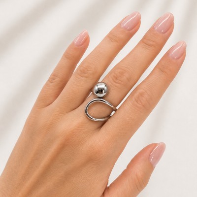 Anillo plateado ajustable de acero inoxidable puesto en mano femenina mostrando diseño moderno y minimalista