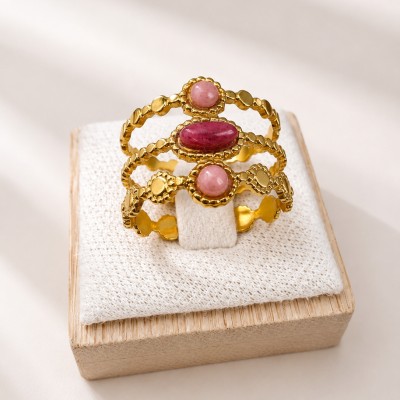 Anillo triple ajustable de acero inoxidable con baño de oro y cuarzo rosa sobre soporte de lino.