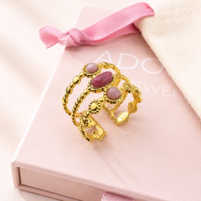 Anillo de acero inoxidable dorado con cuarzo rosa sobre caja de joyería AdoraVi.