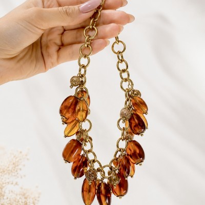 Collar dorado de acero inoxidable con baño PVD y cuentas efecto ámbar sobre fondo blanco