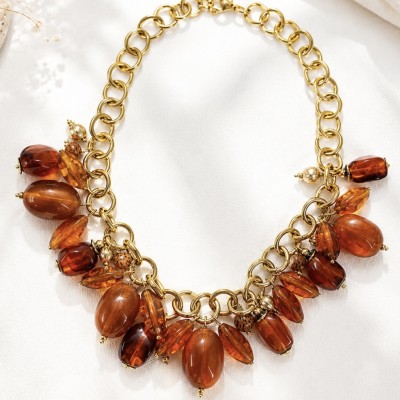 Collar dorado de acero inoxidable con baño PVD y cuentas efecto ámbar sobre fondo blanco