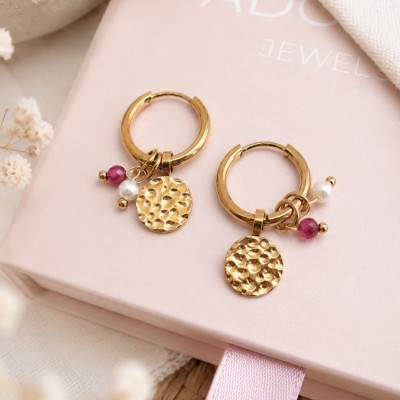 Detalle de pendientes de aro dorados con medalla martillada, jade rojo y perla