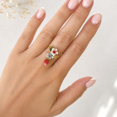 Modelo luciendo anillo ajustable con fresa y flores esmaltadas de estilo romántico.