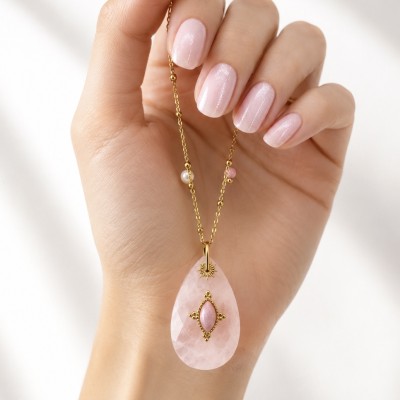 Detalle del collar con colgante de cuarzo rosa natural en forma de lágrima y cadena dorada