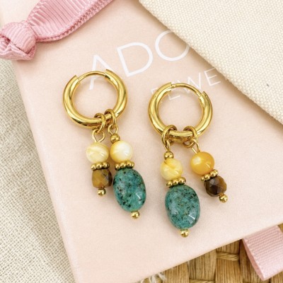 Pendientes de acero inoxidable dorado con piedras naturales sobre bolsa de joyería AdoraVi.